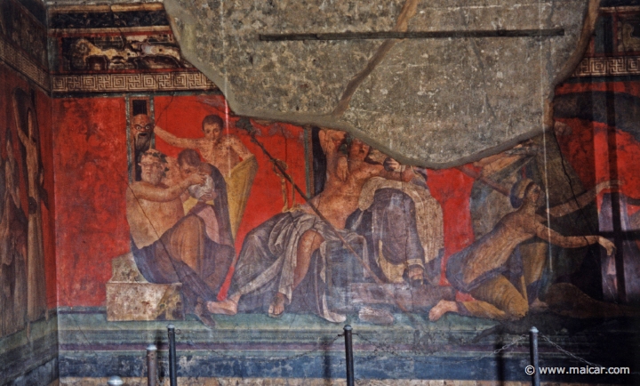 7415.jpg - 7415: Villa dei Misteri, Pompeii. From left to right: Silenus giving a drink to a young Satyr, while another Satyr holds up a frightening mask; Dionysus sits with Ariadne; initiates. Pompeii.